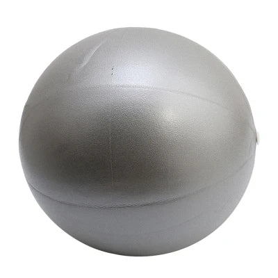 Pink 25cm Fitness Essentials yoga ball used for Pilates, core training, and home workouts, shown inflated on a gym floor.