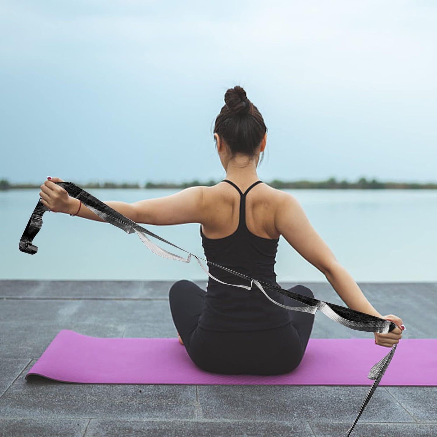 Black and grey yoga stretching strap with 12 loops, used for flexibility, physical therapy, Pilates, and gymnastics exercises.