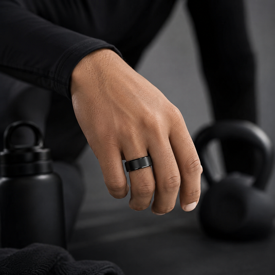 A close-up of a hand wearing a black smart fitness ring for health tracking during a workout.