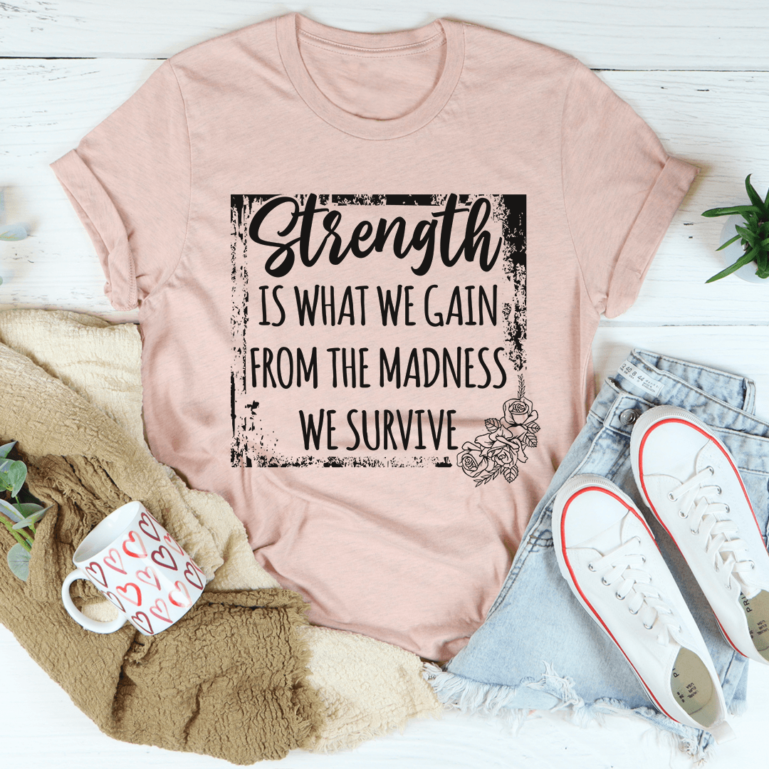 Heather Prism Peach motivational graphic t-shirt featuring the quote "Strength Is What We Gain From The Madness We Survive"