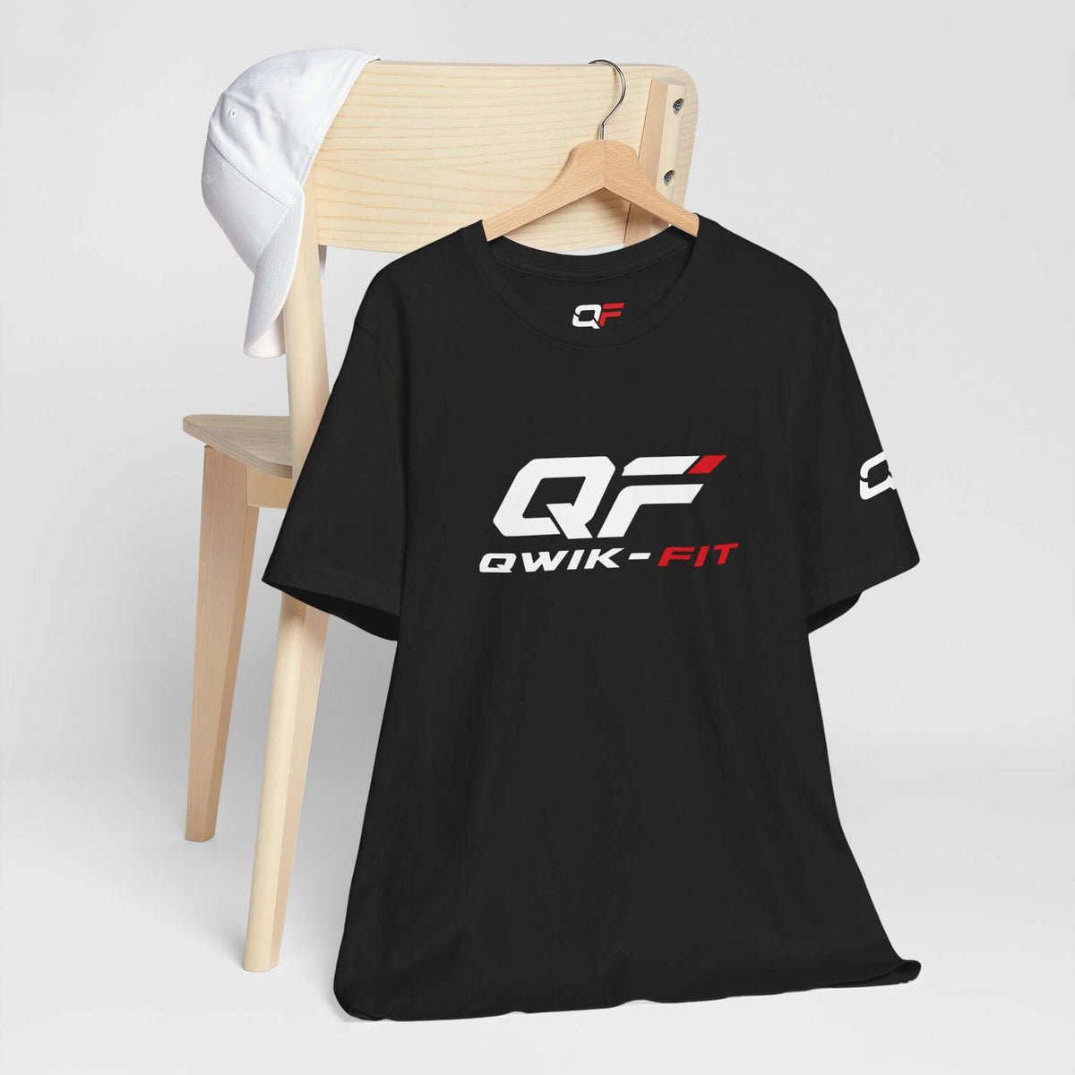 Black Performance Workout T-Shirt displayed on a hanger next to a white cap, ideal for fitness and activewear.