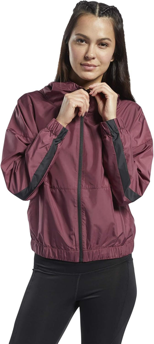 Reebok women's workout-ready hooded jacket in black with front pockets and a drawstring hood for activewear or casual wear.