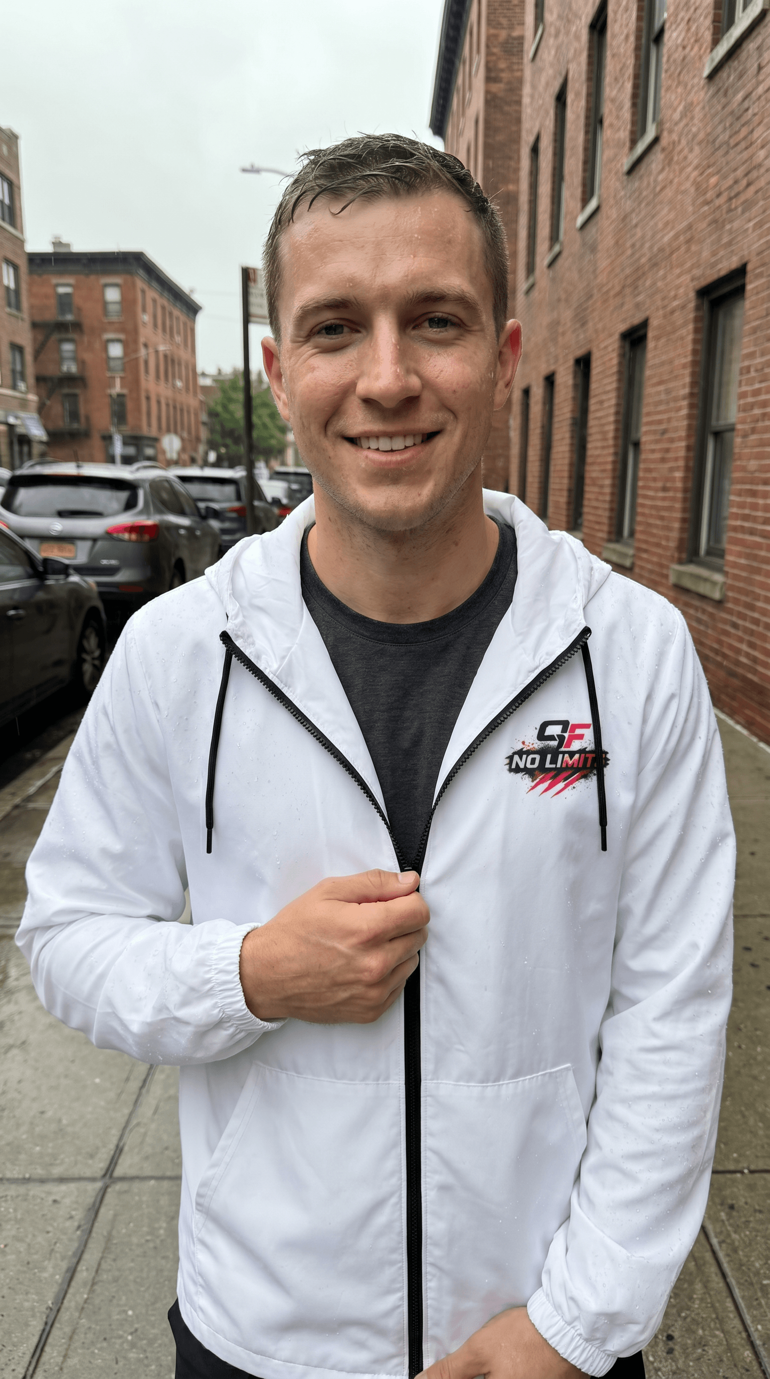Windbreaker jacket for workouts modeled by a man outdoors in rainy weather, showcasing practical and stylish design.