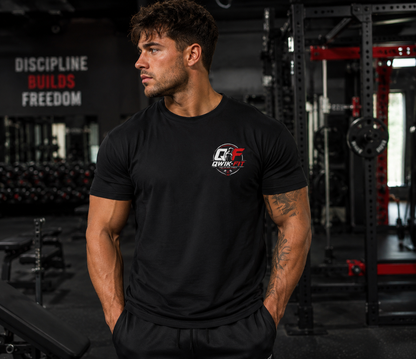Man wearing a black Qwik-Fit t-shirt in a gym setting, showcasing fitness and style.