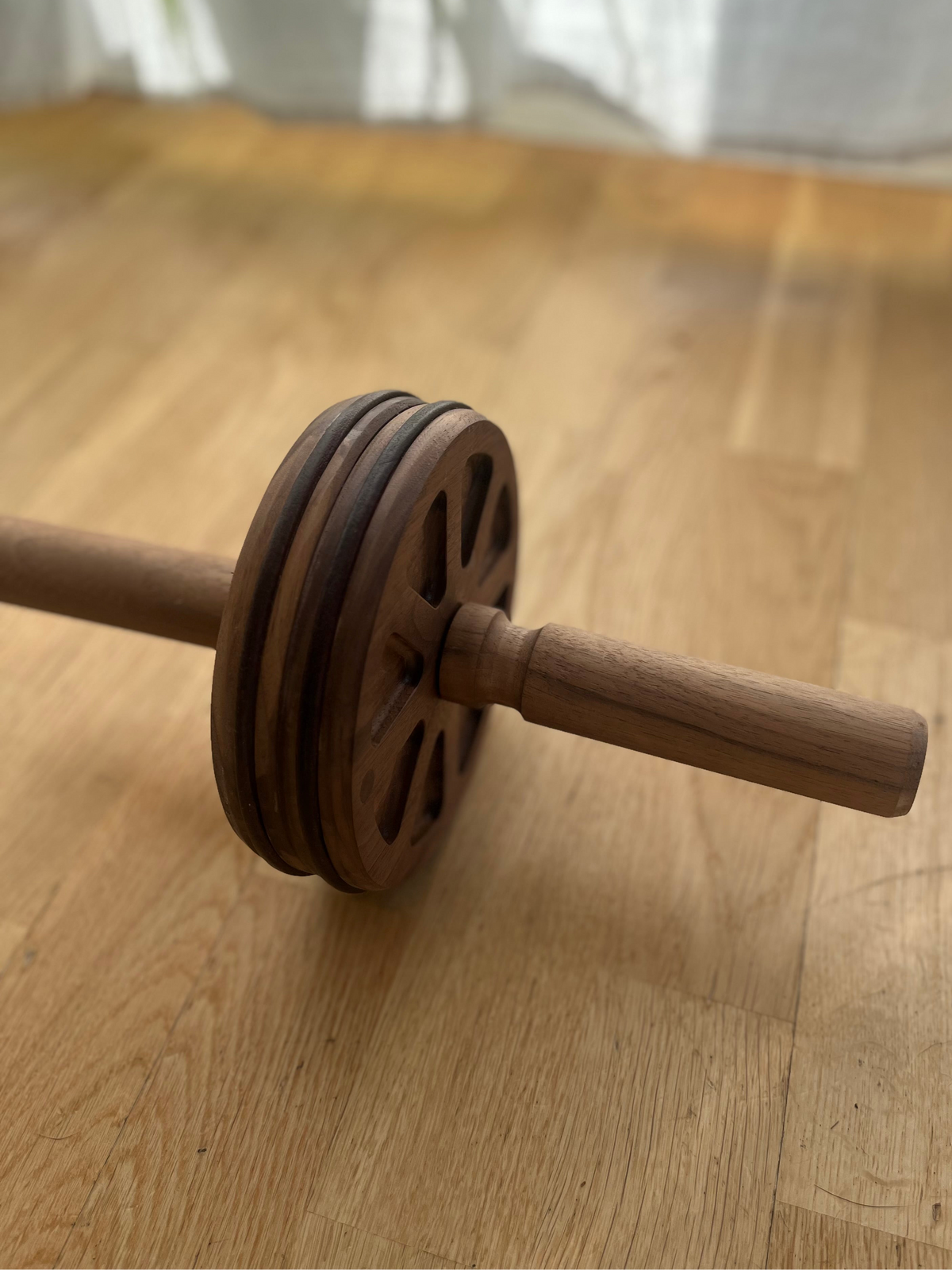 Handcrafted wooden ab wheel home fitness on wooden floor, designed for effective core strength training.