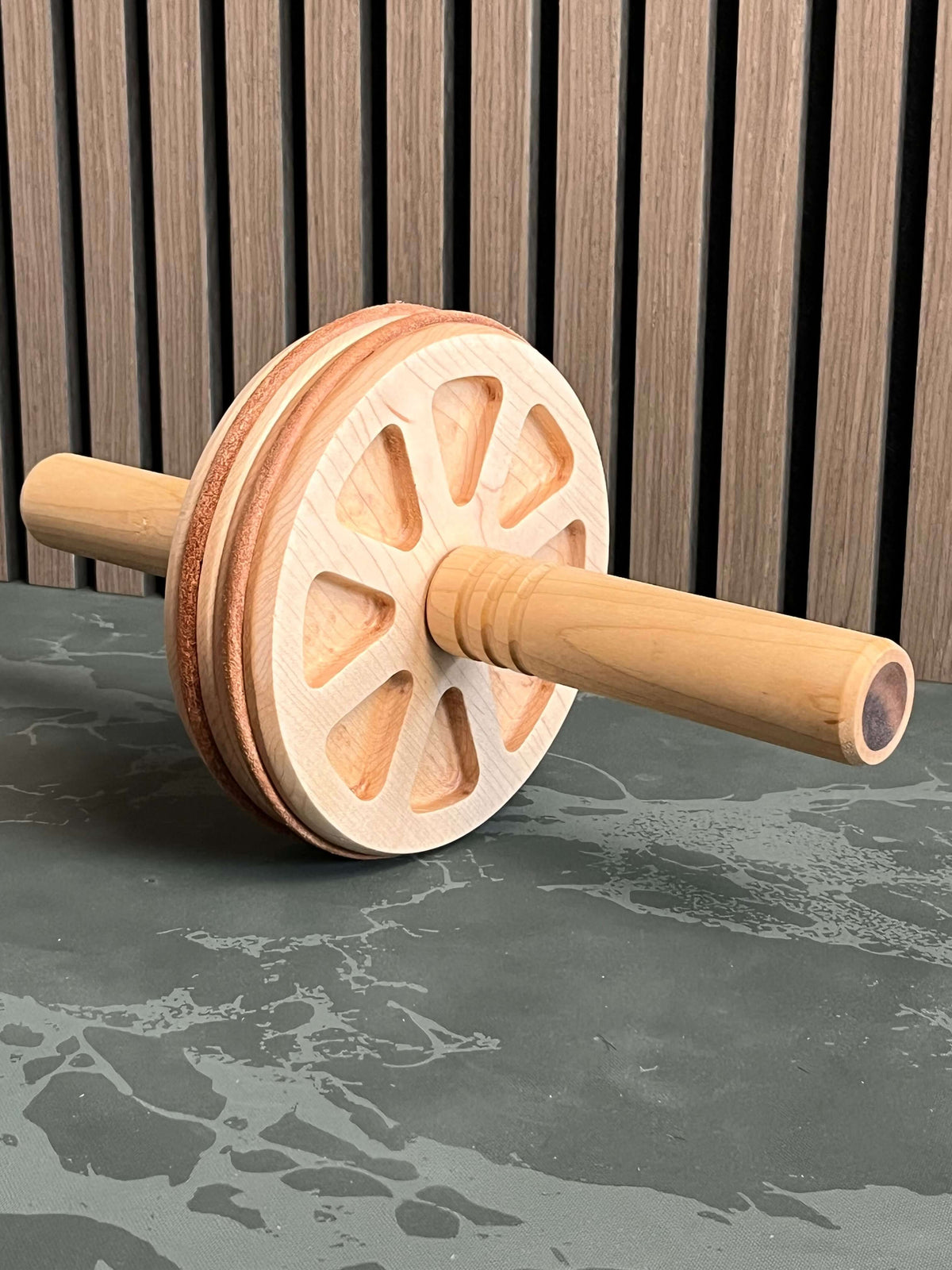 Handcrafted wooden ab wheel home fitness on a surface, perfect for core strength training at home or gym.