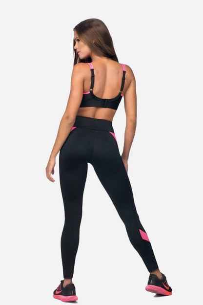 Back view of a woman wearing a black pink sports bra for training and leggings with pink accents.