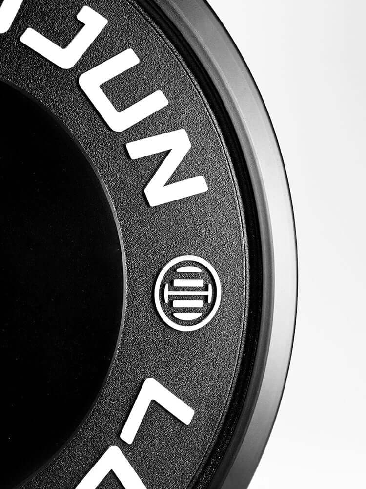Close-up of D Series black rubber barbell plates 150kg showcasing textured design and logo.