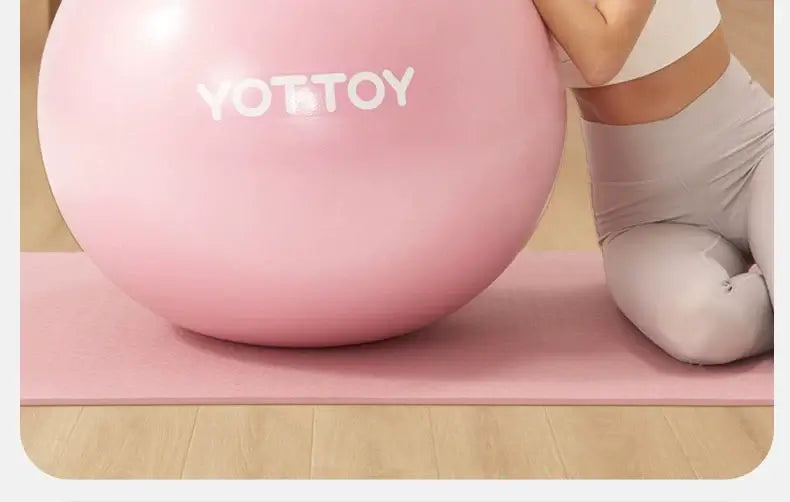 Thickened explosion-proof yoga ball in pink color, ideal for fitness and balance exercises, promoting wellness and stability.