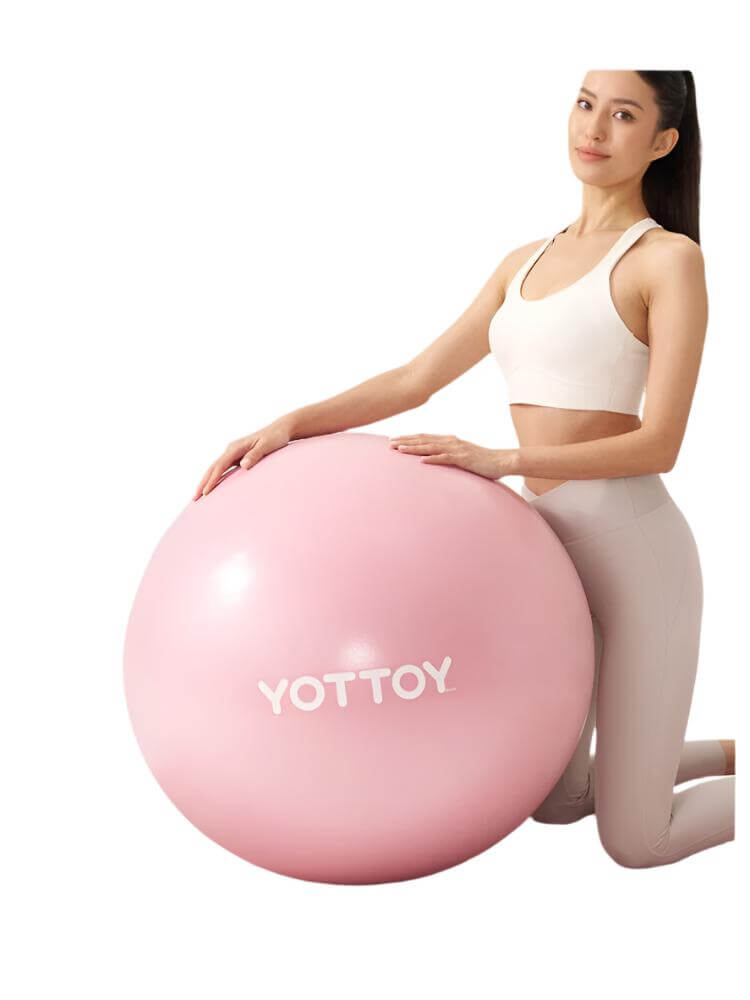 Thickened explosion-proof yoga ball in pink color used for fitness and balance, showcased by a woman in workout attire.