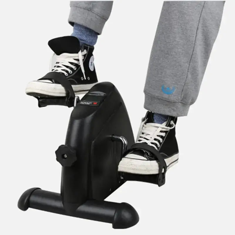 Feet on a home gym mini pedal stepper, ideal for fitness routines and home workouts.