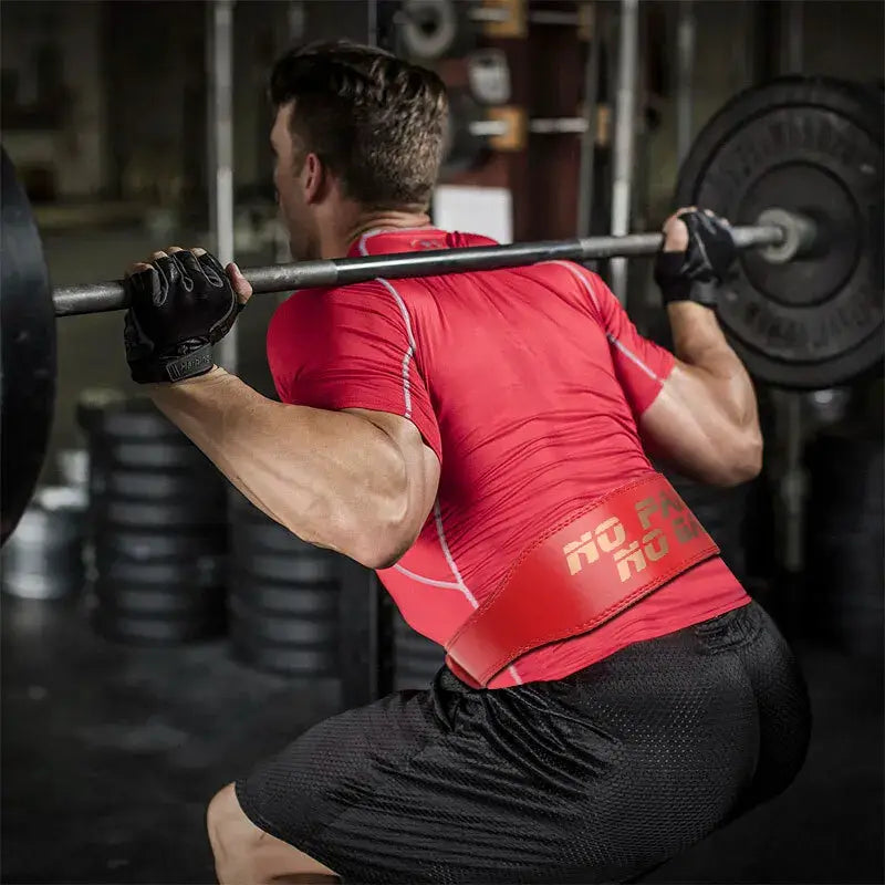 Weight lifting belt for powerlifting in use during a squat exercise at the gym.