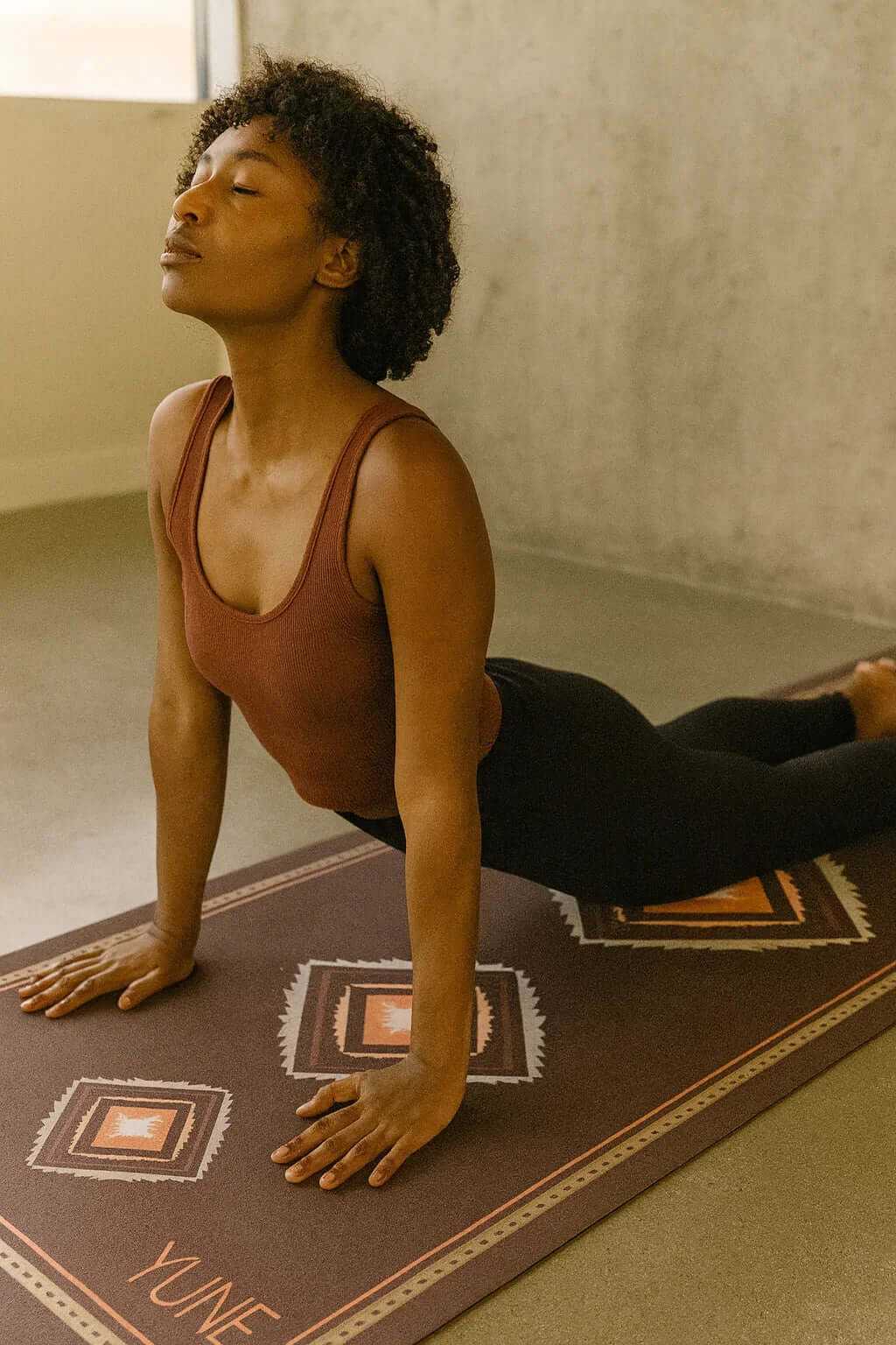 Cactus print yoga mat providing cushioned support during yoga pose for enhanced stability and grip.