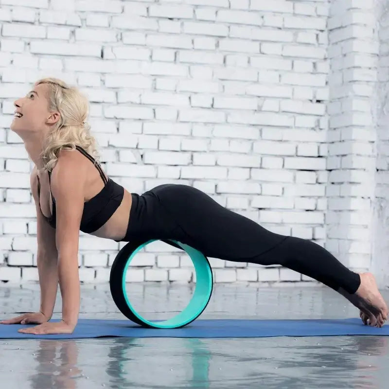 Woman practicing yoga with a durable yoga wheel for balance on a mat, showcasing flexibility and strength.