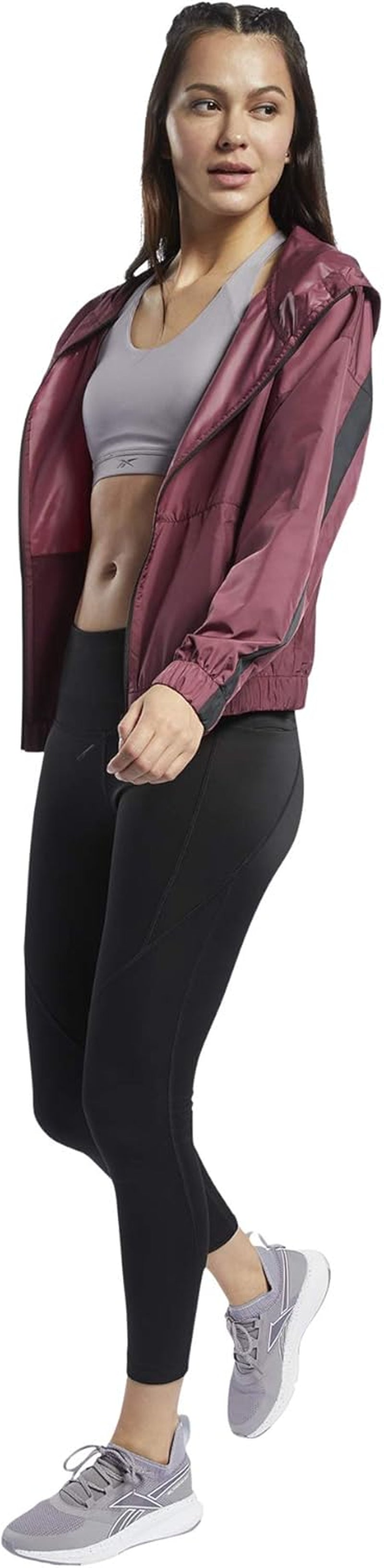 Reebok women's workout ready hooded jacket in black, featuring a zip-up front and adjustable drawstring hood for active wear.