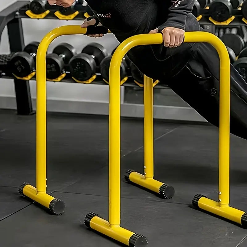 User performing workouts on height adjustable parallel bars in vibrant yellow color.