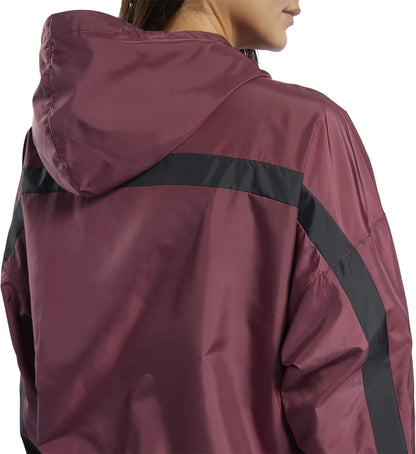 Reebok women's workout ready hooded jacket in black with front pockets and a drawstring hood, suitable for exercise and casual wear.