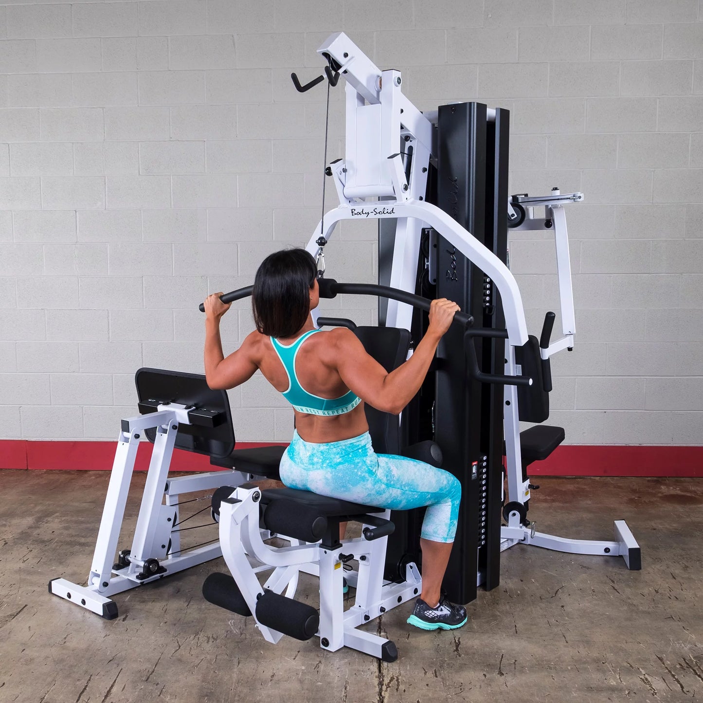 Body Solid EXM3000LPS commercial double stack gym with three stations, featuring adjustable weight stacks and multiple workout stations.