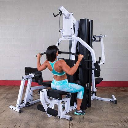 Body Solid EXM3000LPS commercial double stack gym with three stations, featuring adjustable weight stacks and multiple workout stations.