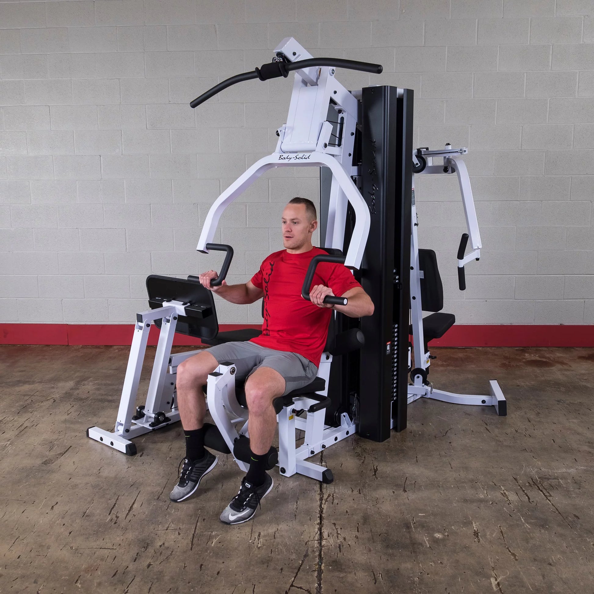 Body Solid EXM3000LPS commercial double stack gym with three workout stations, featuring weight stacks and sturdy frame.