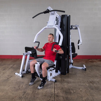 Body Solid EXM3000LPS commercial double stack gym with three workout stations, featuring weight stacks and sturdy frame.