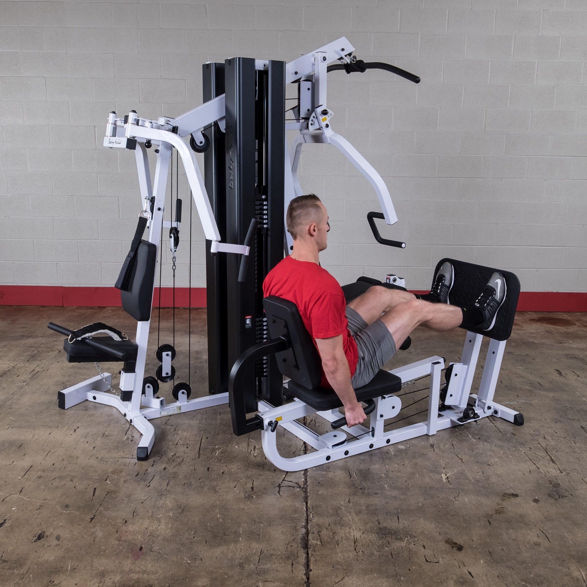 Body Solid EXM3000LPS commercial double stack gym with three workout stations and multiple weight stacks for full-body strength training.