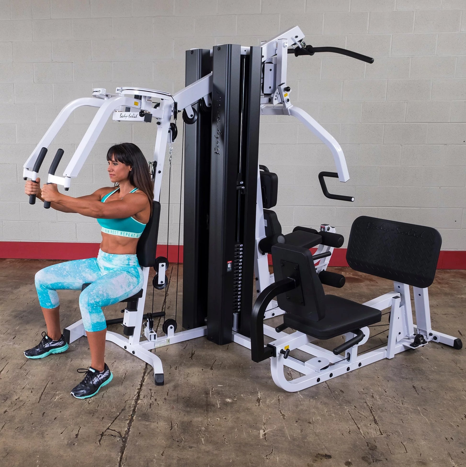 Body Solid EXM3000LPS commercial double stack gym with three workout stations and multiple weight stacks for full-body training.