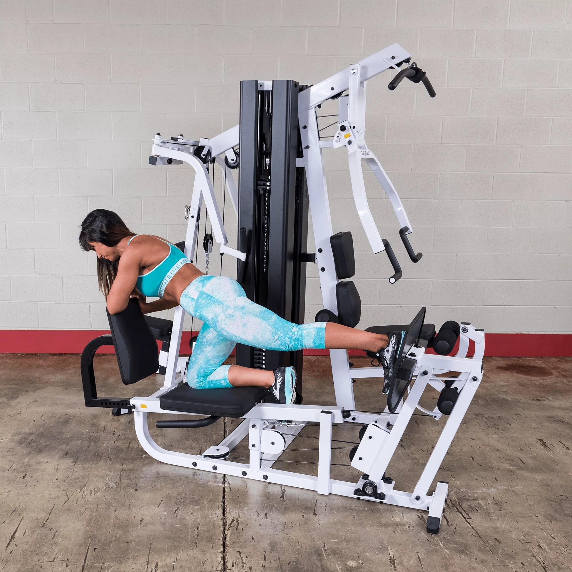Body Solid EXM3000LPS commercial double stack gym with three workout stations, featuring weight stacks and multiple exercise options.