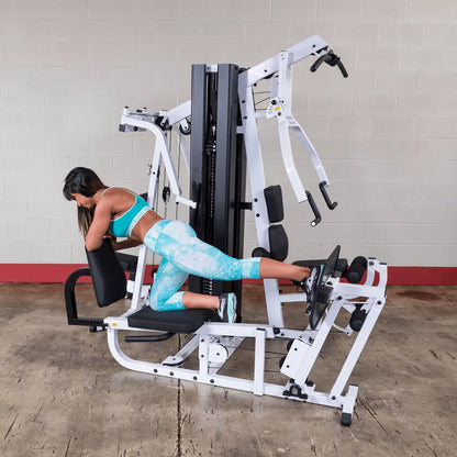 Body Solid EXM3000LPS commercial double stack gym with three workout stations, featuring weight stacks and multiple exercise options.