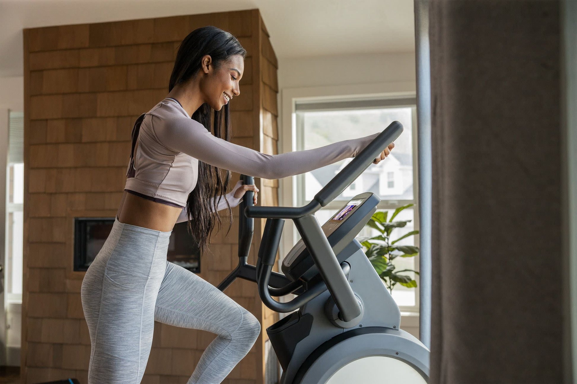 Fitness Essentials Trainer H7 elliptical with 7-inch touchscreen display and built-in fan, shown with sleek design and digital controls.