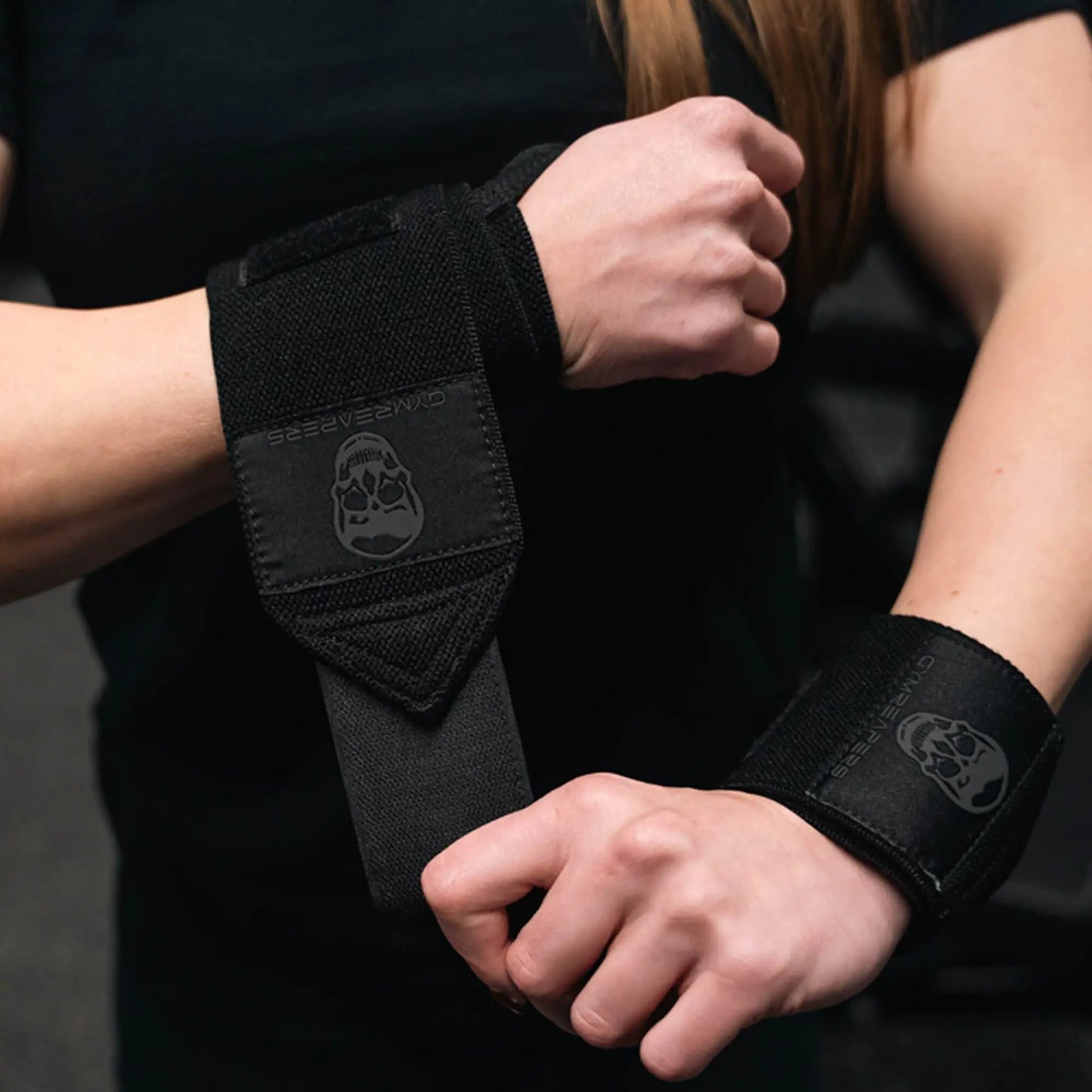 Black gym wrist wraps by My Store 2, featuring adjustable straps and reinforced stitching for wrist support during workouts.