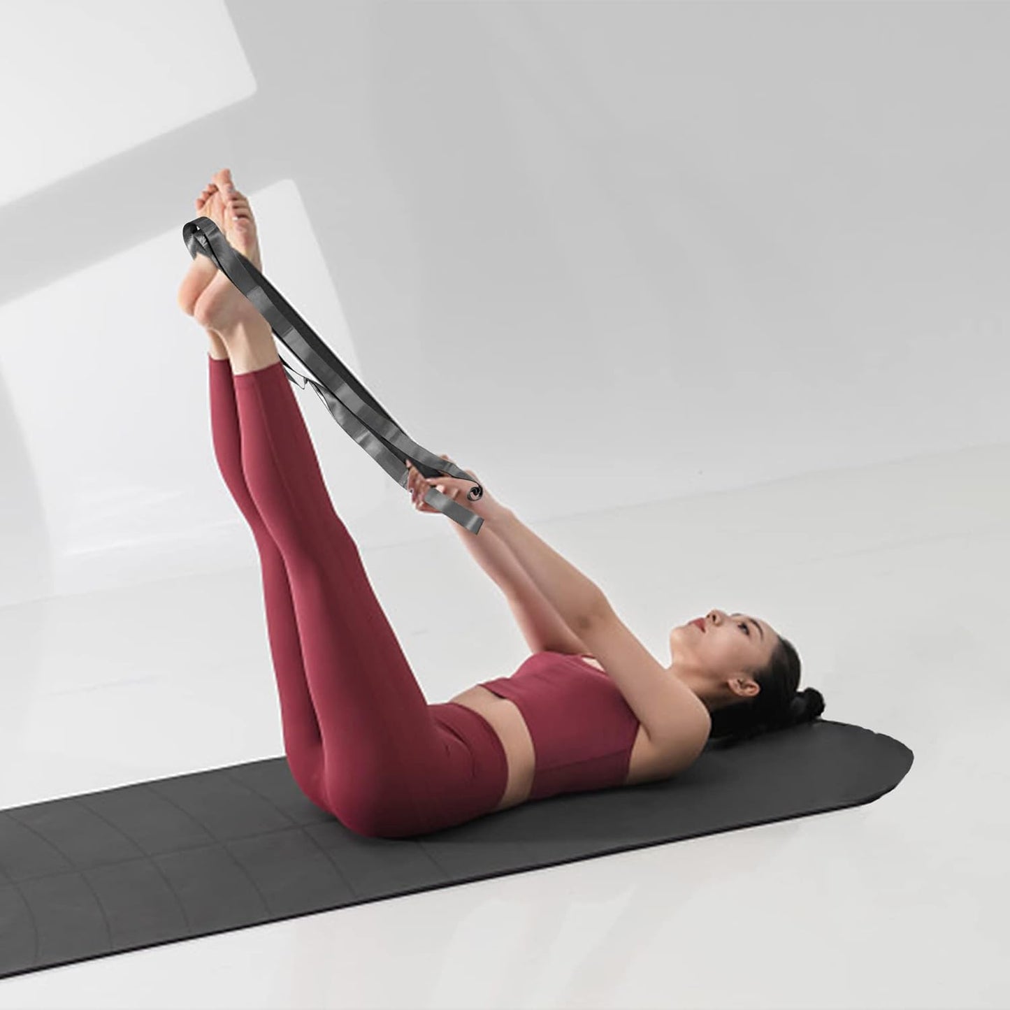 Black and grey yoga stretching straps with 12 loops, used for exercise, Pilates, physical therapy, and gymnastics for men and women.